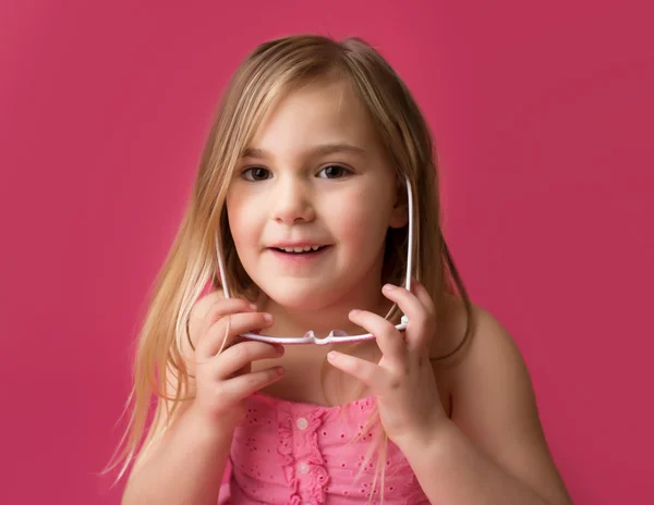 Šťastná dívka s úsměvem v růžové brýle pohledu kamery Stock Snímky