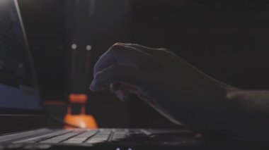 Kadın elleri gecenin geç saatlerinde karanlık odada bilgisayar klavyesinde yavaş çekimde dikkatlice daktilo ediyor.