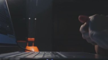 Nazik ellerin yavaşça birbirine sürtünmesi, temiz parmaklar dizüstü bilgisayarın klavyesinde karanlık bir ortamda yazması.