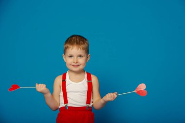 Sevgililer Günü 'nde kırmızı askılı şirin bir çocuk.