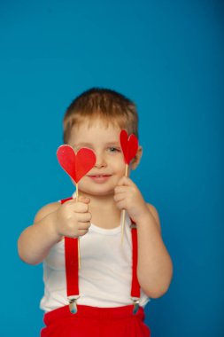 Sevgililer Günü 'nde kırmızı askılı şirin bir çocuk.