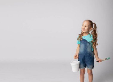 İnşaat aletleriyle beyaz arka planda sevimli bir kız.