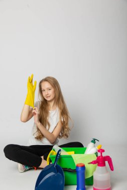 Tatlı kız beyaz bir arka planda temizlik yapıyor.