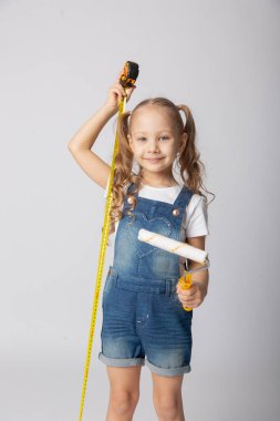 İnşaat aletleriyle beyaz arka planda sevimli bir kız.