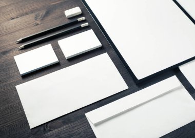 Ahşap masa arka planında boş kırtasiye seti. Marka kimliği şablonu. Grafik tasarımcıları sunumları ve portföyleri için.