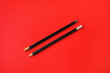 Kırmızı kağıtta kopya alanı olan siyah kalemler. Metin için boşluk.