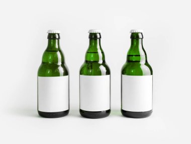 Boş etiketli üç yeşil bira şişesi..