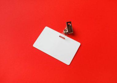 Kırmızı kağıtta boş plastik rozet modeli. Boş isim etiketi maketi. Metin için boşluk.