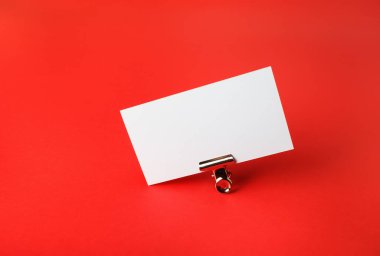 Boş kartvizit ve kırmızı kağıdın üzerine metal ataç. Metin için alanı kopyala.