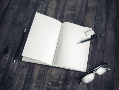 Boş kağıtlar: Ahşap zemin üzerinde kitap, kalem, bardak ve silgi. Tasarımınızı yerleştirmek için ayarlayın.