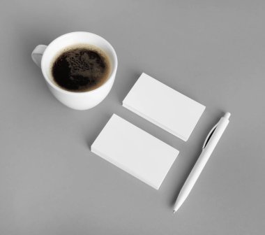 Gri kağıt arka planda boş damgalama kimliği ayarlandı. Kartvizit, kahve fincanı ve kalem. Tasarım sunumları ve portföyleri için.