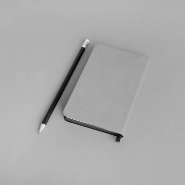 Gri kağıda yazılmış boş not defteri ve kalem. Markalaşma tasarımı için şablon.