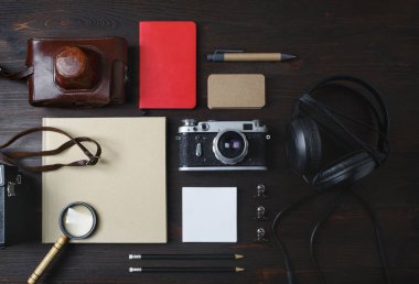 Antika seyahat eşyaları. Boş kırtasiye malzemesi ve ahşap arka planda retro kamera fotoğrafı. Düz yatıyordu.
