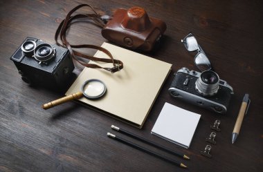 Ahşap masa arkasında retro kamerayla tatil yapmayı planlıyorum..