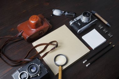 Geçmişe dönük kamera ve ahşap arka planda antika kırtasiye ile planlama gezisi. Seyahat ya da tatil kavramı.