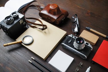 Geçmişe dönük kamera ve ahşap arka planda antika kırtasiyeyle tatil planlama.