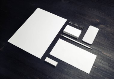 Ahşap masa arka planında boş damgalama kimliği var. Şirket kırtasiye şablonu. Tasarım sunumları ve portföyleri için.