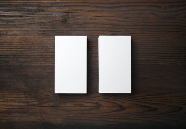 Ahşap arka planda iki boş kartvizitin fotoğrafı. Marka kimlik şablonu. Düz yatıyordu.