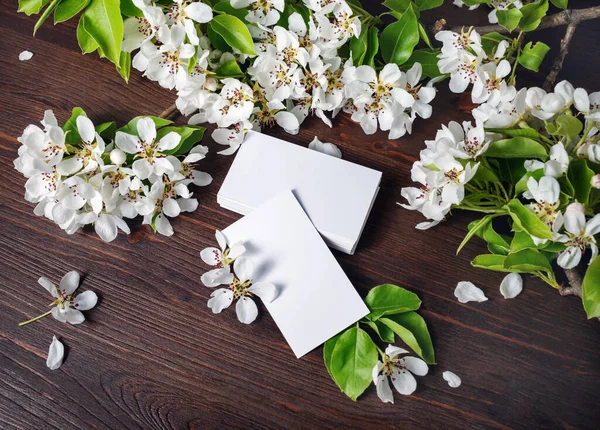 Blank business cards and flowers on wooden background. Template for ID.