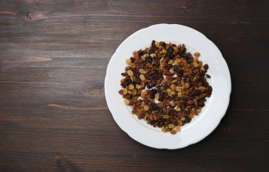 Ahşap masa arka planında kuru üzümler. Düz yatıyordu.