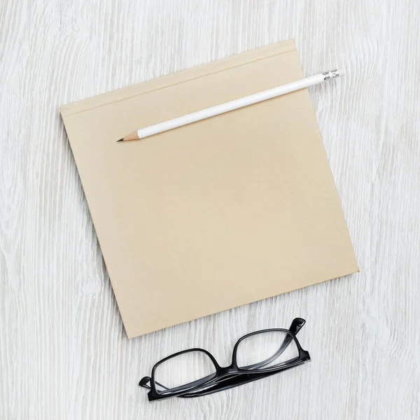 Folheto Quadrado Branco Óculos Lápis Sobre Fundo Madeira Clara Modelo — Fotografia de Stock