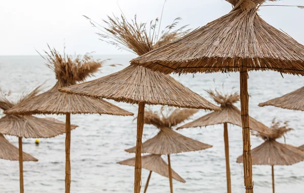 Straw umbrellas on sea background — Stock Photo, Image