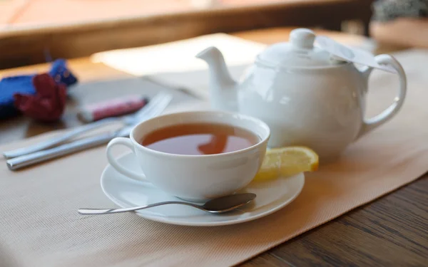 Чашка чая с лимоном и чайником — стоковое фото