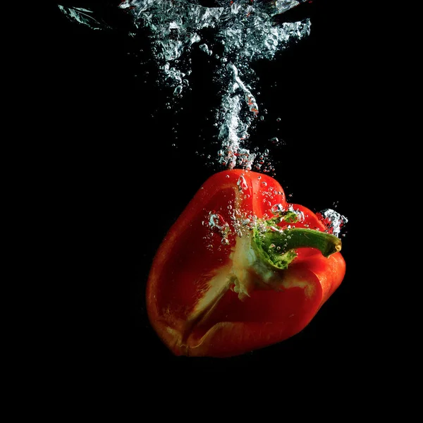 Halbe rote Paprika in Wasser — Stockfoto