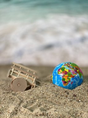 Deniz kenarındaki ahşap arabada ve kumsalda bir küre