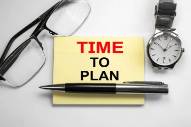 Planlama zamanı, kol saatleri ve gözlükler arasında hafif bir arkaplan üzerine yazılmış bir kağıt parçasına yazılmıştır. İş konsepti