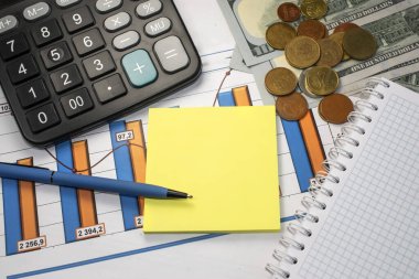 Hesap makinesi ve dolar ve kopek biçimindeki nakit paranın yanına, belgeye üzerinde kalem olan sarı bir kağıt parçası yerleştirilir. İş konsepti. Tex için boşluk