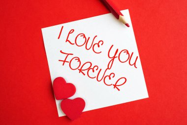 Seni daima beyaz bir kağıda yazılmış kırmızı arka planda yatan iki kalple seviyorum. Sevgililer Günü