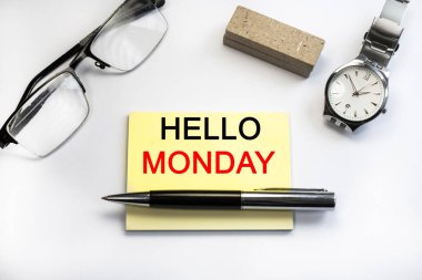 Hello Monday sarı bir kağıda yazılmıştır. Gözlük ve kol saati. Konsept fotoğraf