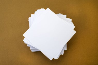 Kahverengi arka planda bir yığın beyaz not kağıdı var. Konsept fotoğraf