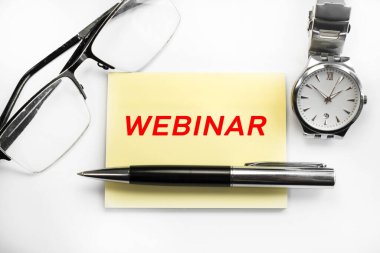 Kol saati ve gözlüklerin yanında açık bir arka planda, üzerinde yazı olan sarı bir çarşaf var. Öğrenme kavramı