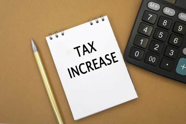Die Steuererhöhung Steht Einem Notizbuch Das Zwischen Taschenrechner Und Gelbem — Stockfoto
