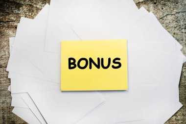 Tahta bir masanın üzerinde beyaz kağıtların üstünde üzerinde 