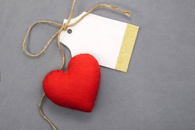 Fiyat etiketi için bir etiket. Kırmızı bir kalbin yanında gri dokulu bir arka plan. Tatil satışları konsepti.