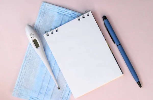 Een Notitieboekje Met Pen Ligt Het Medische Masker Bij Thermometer — Stockfoto