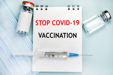 Yazıt aşısı defterdeki covid-19 'u durdurdu. Tıbbi maske ve şırıngalı ampul. Tıbbi konsept. Nüfusun aşılanması