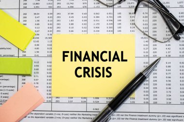 Sarı bir kağıttaki yazıt krizi. Gözlüklü finansal bir belge ve renkli çıkartmalı bir kalem. İş ve mali konsept
