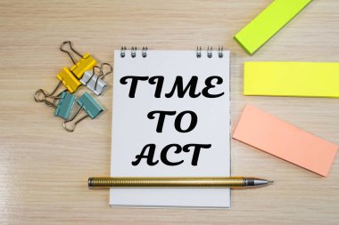 Not defterindeki yazıya göre harekete geçme zamanı. Renkli ataçlar ve yapışkan not kağıtları.