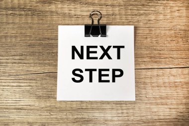 Tahta bir masanın üzerinde, siyah harflerle yazılmış notlar için beyaz bir çarşaf var..