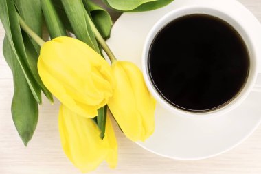 Beyaz bir kahve fincanı ve bir buket sarı lale manzarası. Duvar Kağıdı