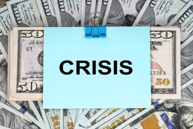 Kriz kelimesi bir yığın doların üzerinde duran mavi bir kağıda yazılmıştır. İş ve mali konsept