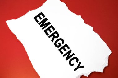 Acil durum kelimesi kırmızı arka planda duran beyaz bir çarşafa yazılır.