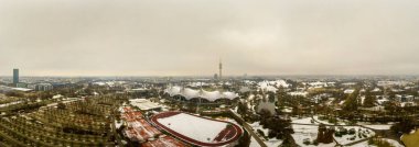 Panoramic view over Munich at the snowy wintertime, captured as an aerial from the beautiful park in the bavarian city.