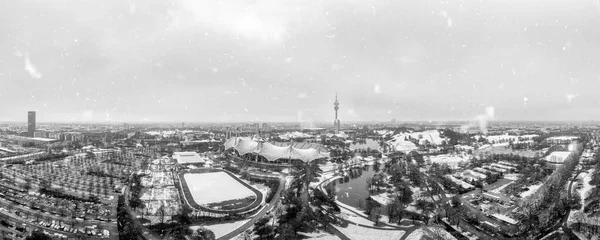 Hópelyhek München felett, a bajor város télen, panorámás kilátással az olimpiai parkra, hó borította. — Stock Fotó