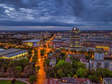 Aydınlatılmış Münih 'in muhteşem alacakaranlık manzarası. İş bölgesi ve arabalar yüksek perspektiften yol üzerinde..
