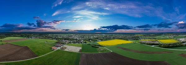 Widok rolniczy na pola uprawne i idylliczną wioskę w tle, schwytaną przez drona z przestrzenią do kopiowania w południowej Bawarii, Niemcy. — Zdjęcie stockowe
